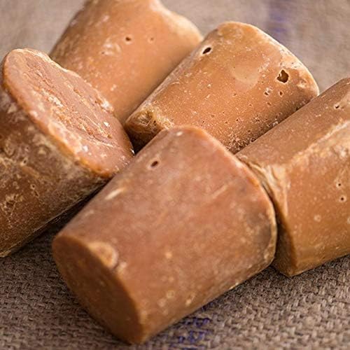 Close-up of Natco jaggery block showing natural brown unrefined cane sugar texture used in South Asian cuisine.