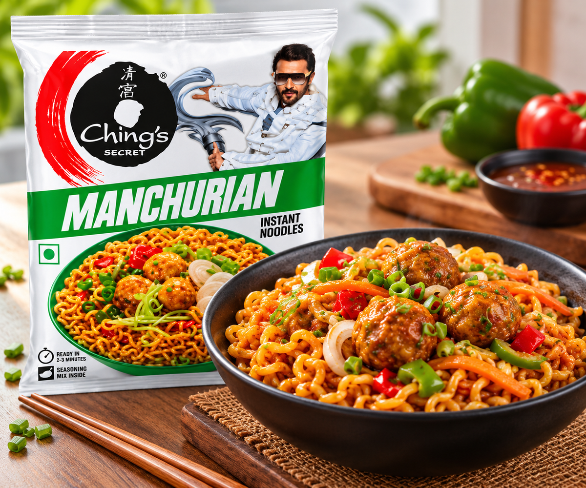 Ching’s Secret Manchurian Instant Noodles 60g packet displayed behind a black bowl of cooked Manchurian noodles with vegetables, spring onions, and saucy Manchurian balls, with chopsticks, fresh vegetables, and dipping sauce on a wooden table.