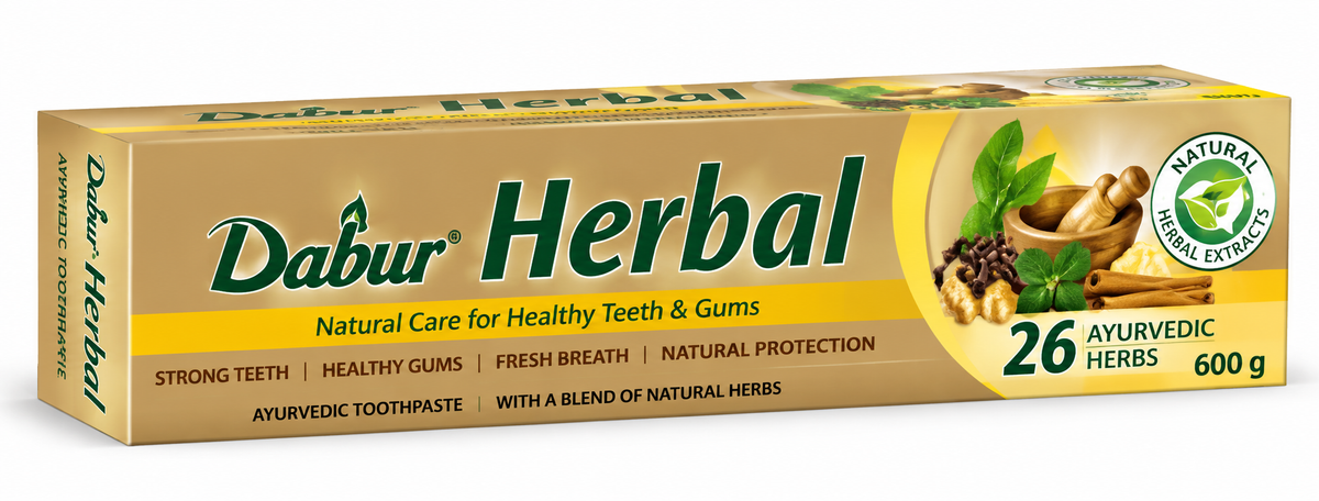 Dabur Herbal Ayurvedic Toothpaste 600g box featuring golden-yellow and tan packaging, the green Dabur Herbal logo, natural herbal extract branding, and illustrations of herbs, leaves, cloves, and cinnamon. The front of the toothpaste carton highlights 26 Ayurvedic herbs and natural oral care messaging, displayed against a clean white background.