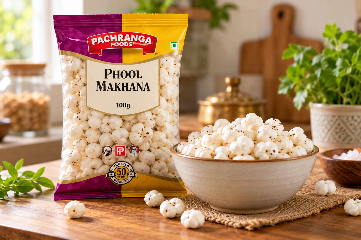 Pachranga Foods Phool Makhana 100g pack displayed beside a bowl of white puffed lotus seeds on a wooden kitchen table, ideal for Indian snacking.