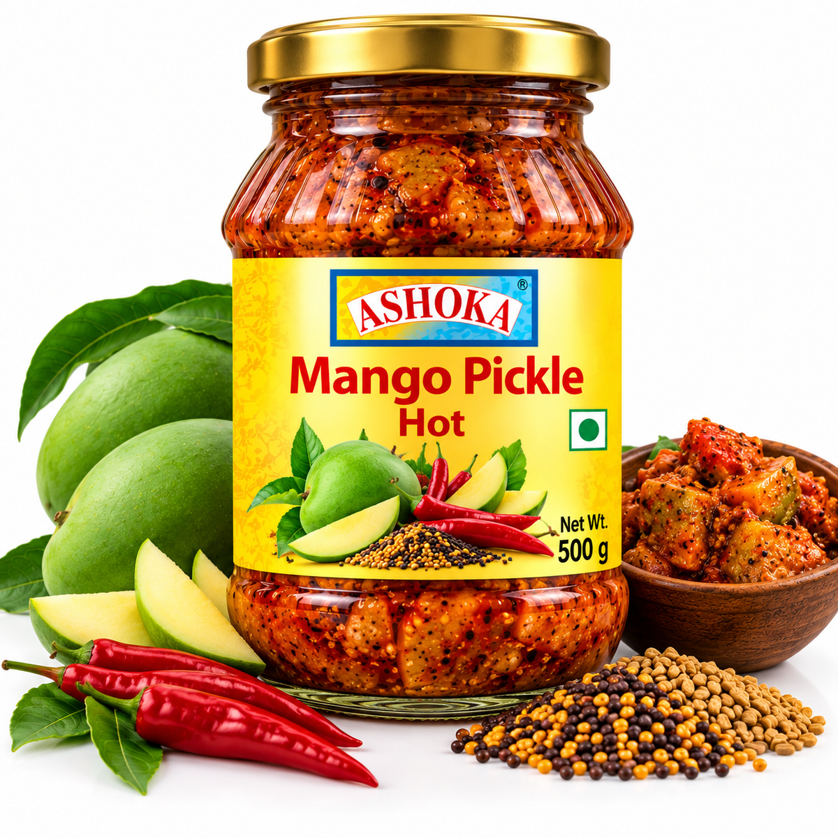 Ashoka Mango Pickle Hot 500g featuring a glass jar with a gold lid and bright yellow label, filled with spicy mango pickle, alongside fresh green mangoes, sliced mangoes, red chillies, mustard seeds, and aromatic Indian spices.