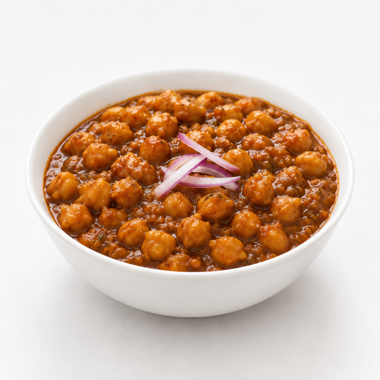 Ashoka Punjabi Choley served in a white bowl with authentic chickpea curry, garnished with fresh onion slices on a clean white background.