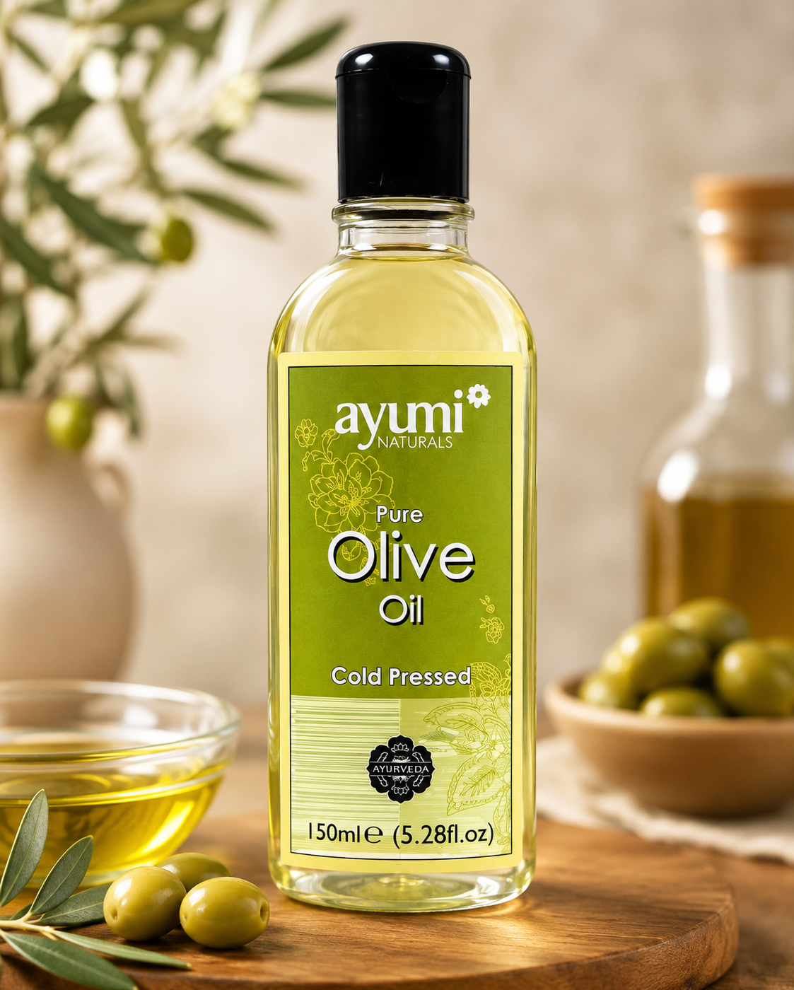 A bottle of Ayumi Naturals Pure Olive Oil, 150ml, standing on a wooden cutting board with fresh olives and olive branches in a warm, rustic setting.