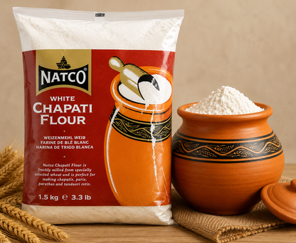 A 1.5 kg bag of Natco White Chapati Flour displayed next to a terracotta clay pot filled with flour and a small wheat stalk on a rustic wooden surface.