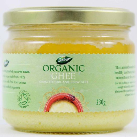 Glass jar of Dabur Organic Ghee 230g with a gold lid and light green label reading “Organic Ghee – Grass Fed Organic Cow Ghee,” showing golden clarified butter inside.