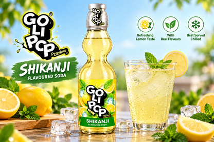 Goli Pop Shikanji Flavoured Soda bottle displayed with a chilled glass of lemon soda, fresh lemons, mint leaves and ice cubes in a bright outdoor-style setting.