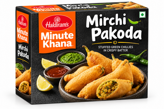 Haldiram’s Minute Khana Mirchi Pakoda 280g box featuring orange and black packaging, crispy golden stuffed green chilli pakodas served with green chutney, red sauce, and lemon wedges.