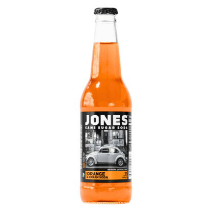 Jones Soda Orange & Cream 355ml bottle displayed on a flat surface, showcasing the clear glass bottle, vibrant orange soda, and distinctive photo label that reflects the brand’s fun and unconventional personality.