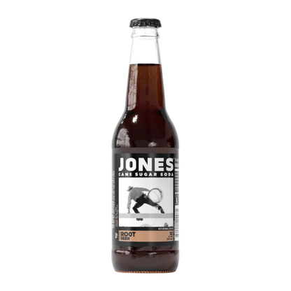 Jones Soda Root Beer 355ml bottle displayed on a flat surface, showcasing the clear glass bottle, dark soda color, and distinctive photo label that gives each bottle a unique look.