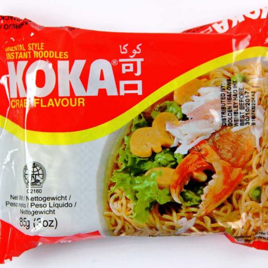 Koka Crab Flavour Noodles 85g instant noodle packet featuring seafood-themed packaging alongside a prepared bowl of wheat noodles in savoury crab-flavoured broth. Single serve instant noodles ideal for quick meals, office lunches, student snacks and convenient everyday cooking.