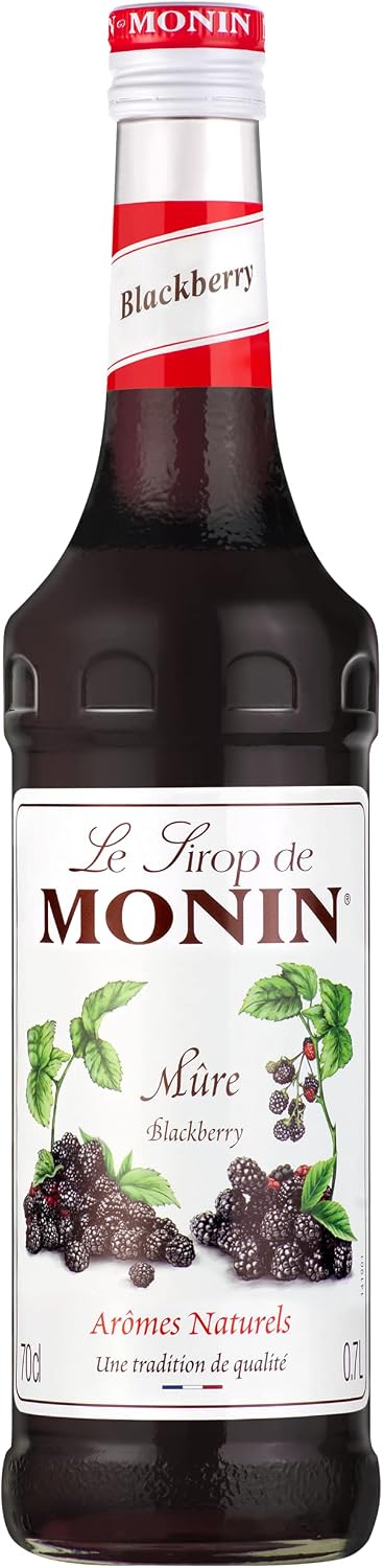 A bottle of Monin Blackberry syrup, featuring a dark glass bottle with a white and red neck label and a detailed white front label depicting fresh blackberries.