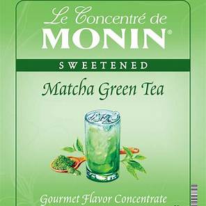 Iced matcha latte made with MONIN Matcha Green Tea Syrup, served with ice and milk in a glass on a wooden table.