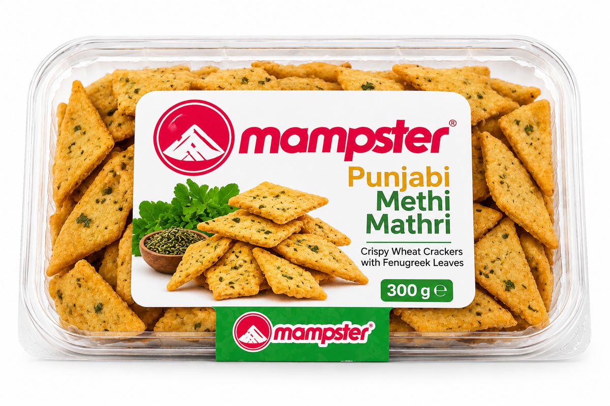 Mampster Punjabi Methi Mathri 300g featuring a clear plastic tray filled with golden, crispy diamond-shaped mathri crackers with fenugreek leaves, and branded packaging with fresh methi imagery.