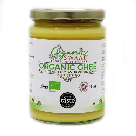 Front-facing image of Organic Swaad Organic Ghee 450g in a clear glass jar with gold lid, displaying organic certification logos and pure clarified butter made in the UK from grass-fed milk.