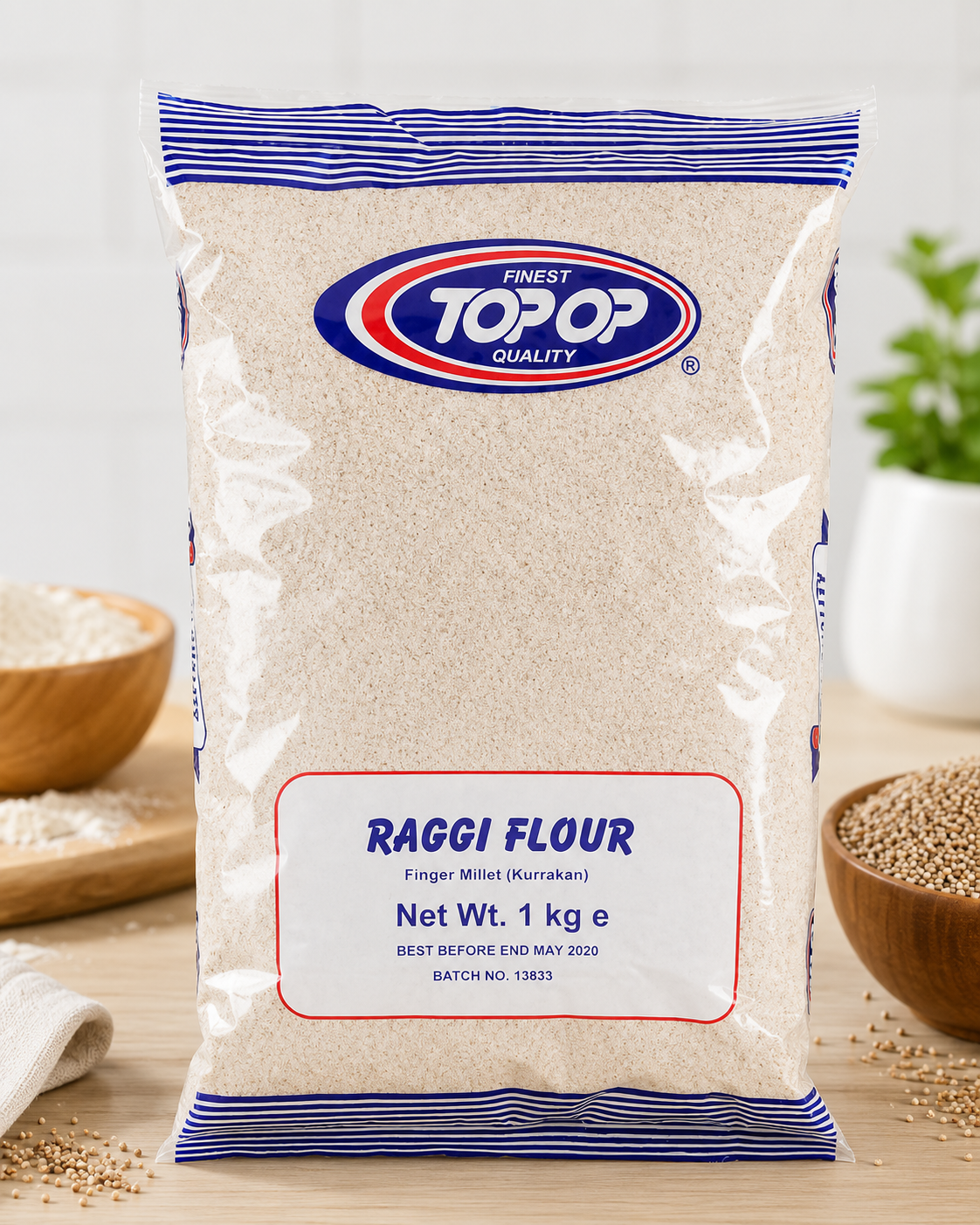 A 1 kg bag of Topop Raggi Flour (Finest White Kurukbarli) on a wooden surface with bowls of grains in the background.