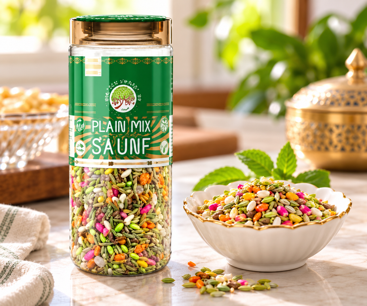 Aryan Plain Mix Saunf 160g jar displayed beside a white bowl filled with colourful fennel mouth freshener on a warm kitchen table, with green leaves and scattered saunf seeds.