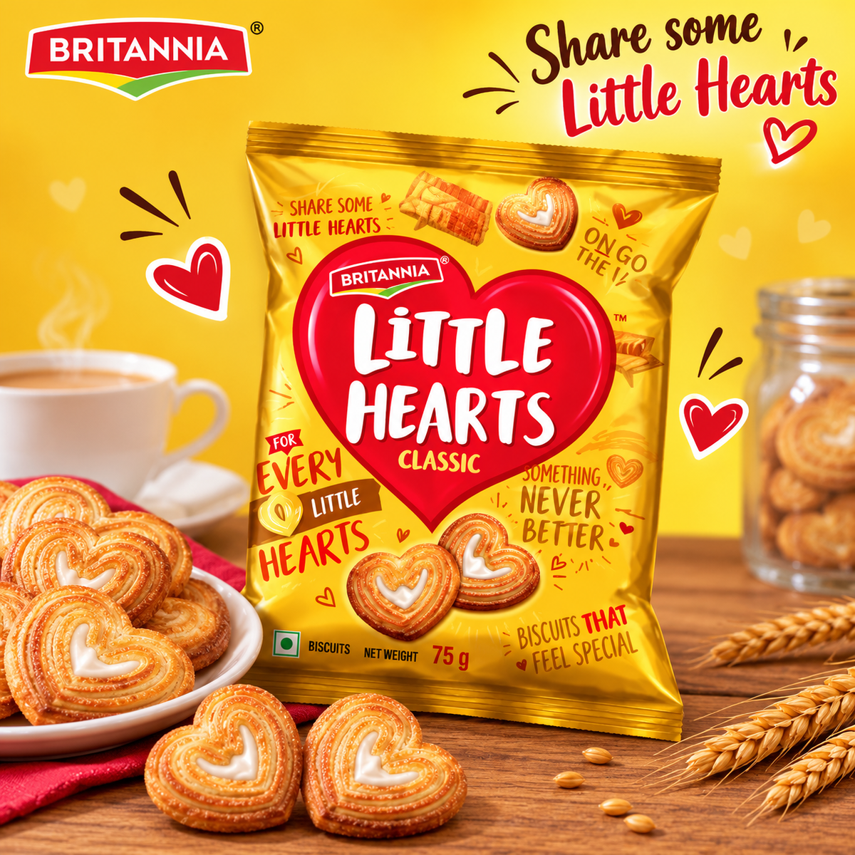 Britannia Little Hearts Classic 75g biscuits in golden packaging, displayed with heart-shaped biscuits, a cup of tea and a warm yellow background.