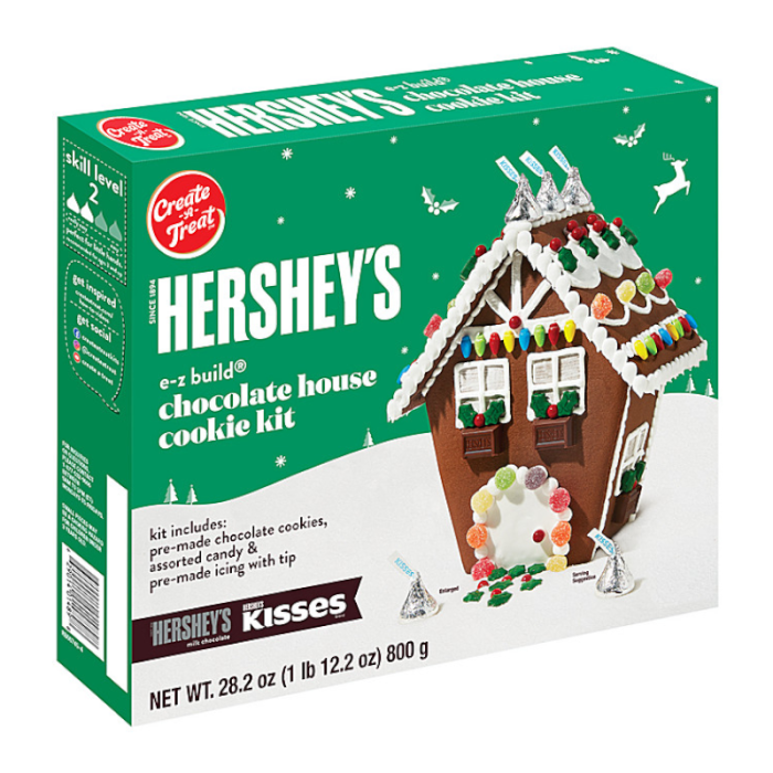 Contents of a Hershey’s chocolate cookie house kit: unassembled cookie panels, icing and assorted candy pieces.
