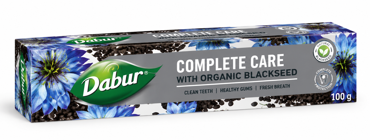 Dabur Blackseed Complete Care Toothpaste 100g carton featuring a green Dabur logo, blue floral designs, blackseed illustrations, and a gray central panel with “Complete Care” branding. The toothpaste packaging is displayed at an angle against a clean white background.