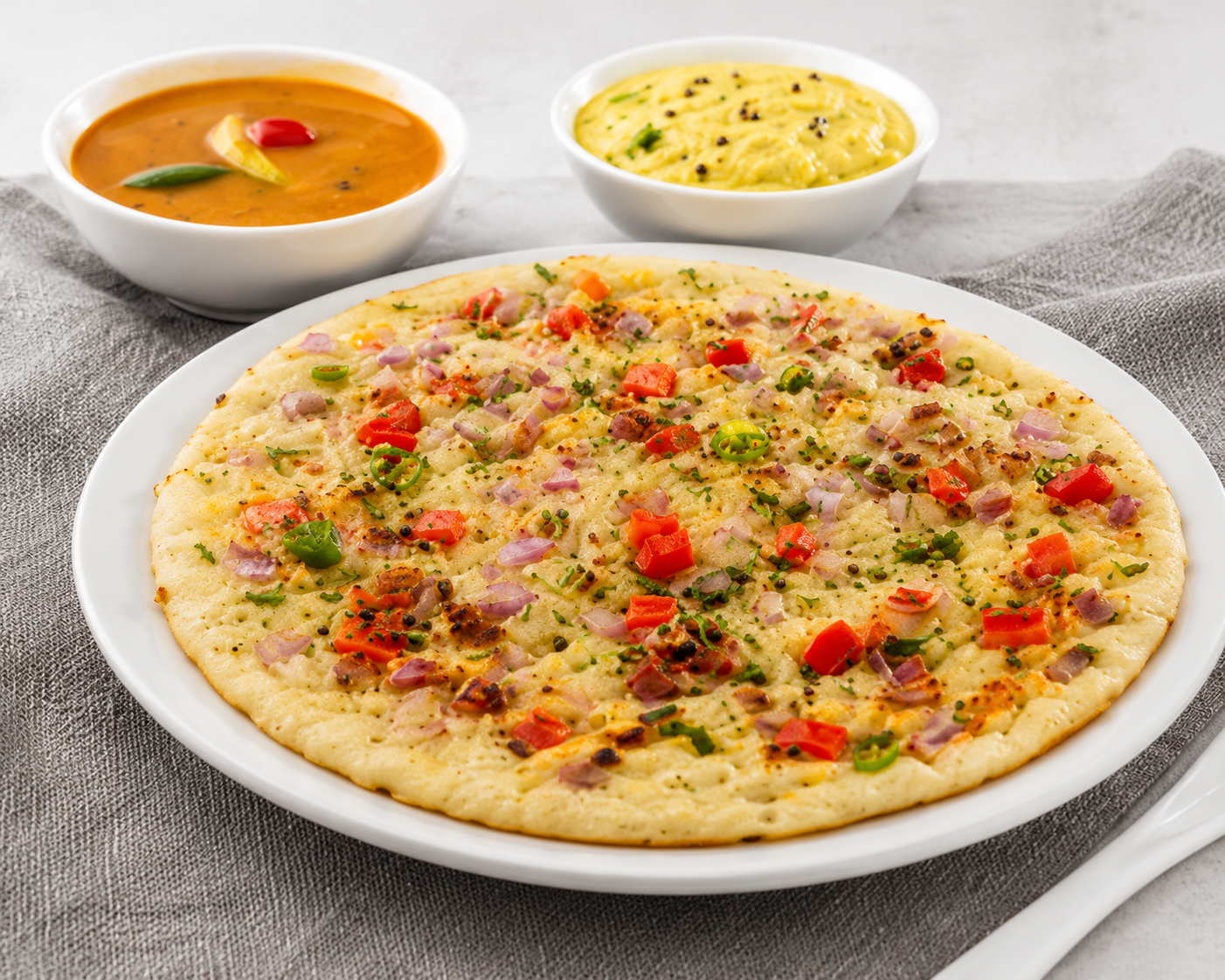 Freshly prepared Gits Uttappam topped with onions, tomatoes and green chillies, served with traditional South Indian sambar and coconut chutney.