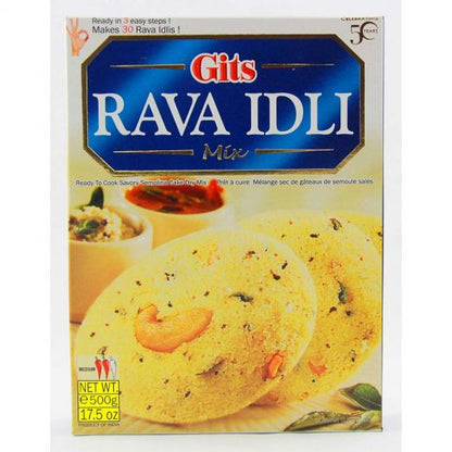 Front view of Gits Rava Idli Mix 500g box packaging, featuring two yellow semolina idlis with visible cashews and spices, served with chutney and sambar in the background, blue and white branding at the top, and “Ready in 3 easy steps” text on the package.