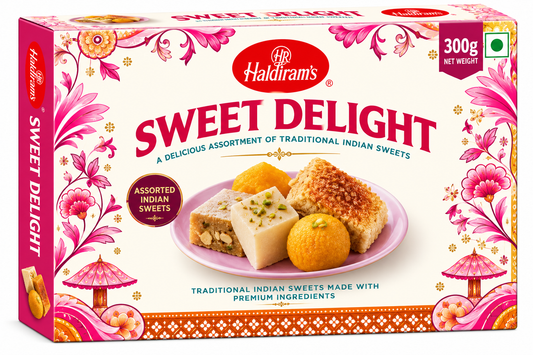Haldiram’s Sweet Delight 300g assorted traditional Indian sweets, including ladoo and burfi, in decorative pink, cream and gold packaging.
