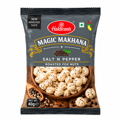 Haldiram’s Magic Makhana Salt N Pepper Roasted Fox Nuts 40g packet featuring charcoal-grey packaging, gold accents and pepper-seasoned roasted makhana on a plain white background.