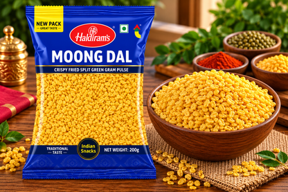 Haldiram’s Moong Dal snack packet displayed beside a wooden bowl of golden crispy moong dal, with spices and green leaves on a rustic wooden table.