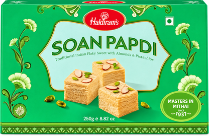 Haldiram’s Soan Papdi 250g front packaging featuring traditional Indian flaky sweet with almonds and pistachios, green decorative box design, Haldiram’s branding, vegetarian symbol and detailed product presentation