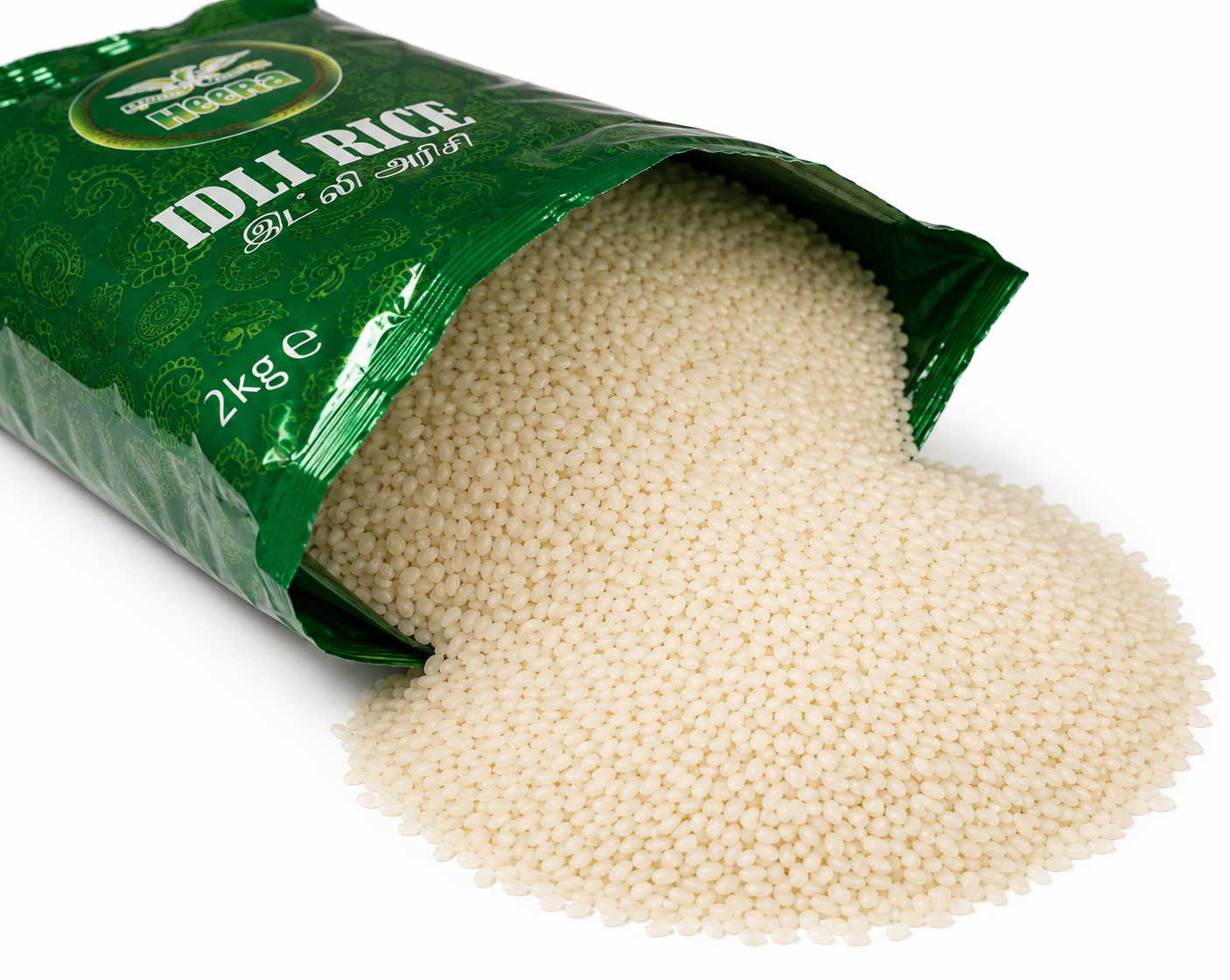 Heera Idli Rice spilling from an opened 2kg green pack onto a white background, showing premium short-grain idli rice.