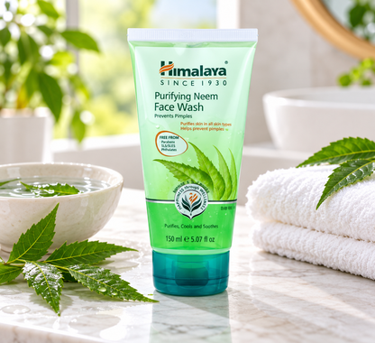 Himalaya Purifying Neem Face Wash Gel 150ml green tube displayed on a marble bathroom countertop beside fresh neem leaves, a ceramic bowl of water, and a folded white towel in a bright, natural skincare setting.Himalaya Purifying Neem Face Wash Gel 150ml green tube displayed on a marble bathroom countertop beside fresh neem leaves, a ceramic bowl of water, and a folded white towel in a bright, natural skincare setting.