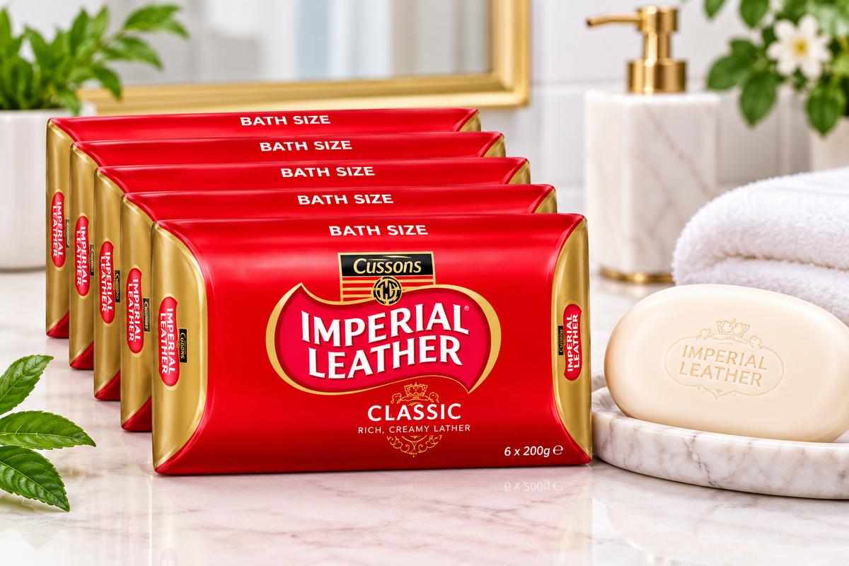 Imperial Leather Classic Soap multipack displayed beside an ivory soap bar on a marble bathroom countertop with a white towel, green leaves and gold bathroom accessories.