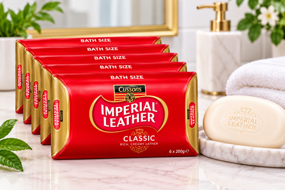 Imperial Leather Classic Soap multipack displayed beside an ivory soap bar on a marble bathroom countertop with a white towel, green leaves and gold bathroom accessories.
