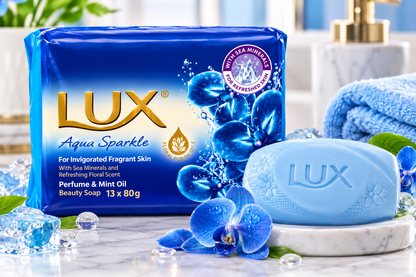 Lux Blue Aqua Sparkle Soap multipack displayed with a pale blue Lux soap bar, blue orchids, water droplets and a marble soap dish.