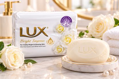 Lux Bright Impress white beauty soap bar and multipack displayed on a marble vanity with white roses, pearls and a gold-rimmed soap dish.