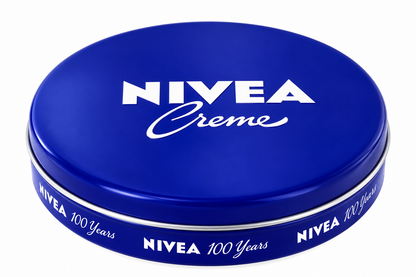 NIVEA Creme 60ml round blue cream tin featuring the iconic white NIVEA logo and Creme lettering on a glossy cobalt-blue lid, with a matching blue side band and silver rim, displayed against a clean white background.