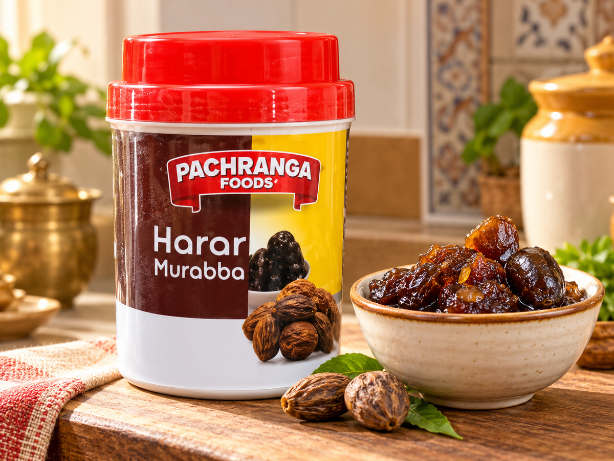 Pachranga Foods Harar Murabba 800g tub displayed beside a ceramic bowl of glossy Harar Murabba preserve on a rustic kitchen table, with preserved fruit, green leaves, and warm kitchen decor.