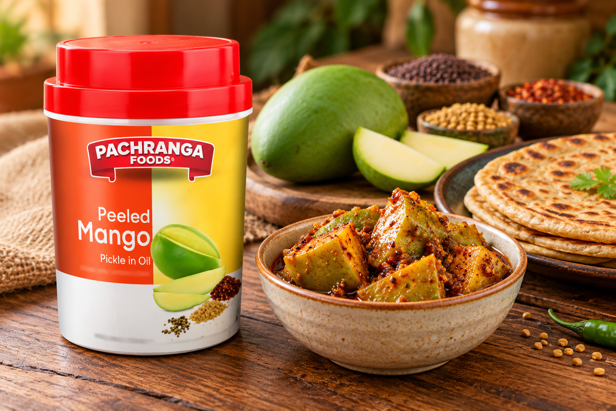 Pachranga Foods Peeled Mango Pickle 800g jar displayed beside a bowl of spicy mango pickle, fresh green mango, Indian spices, and parathas on a rustic wooden table.