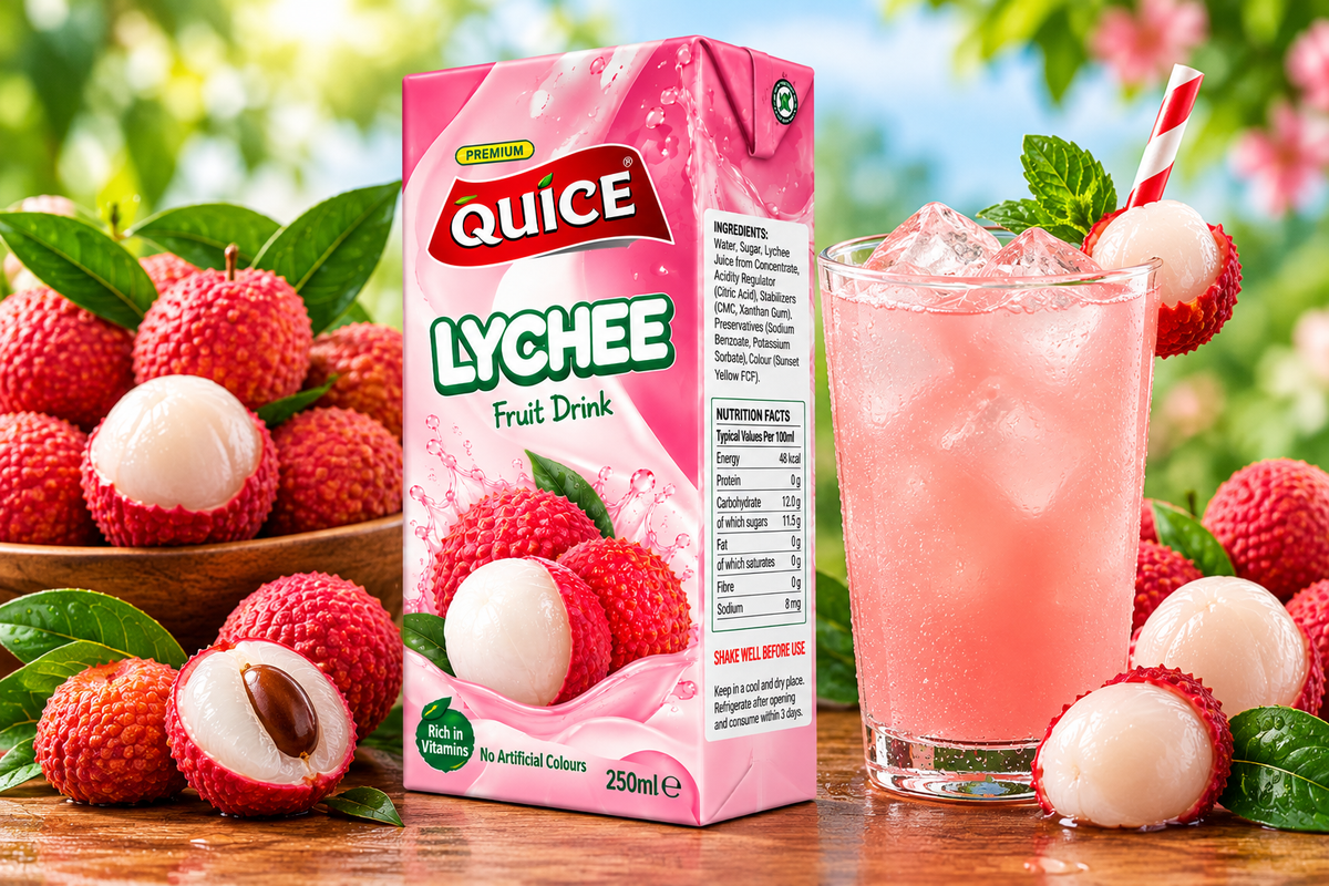 Quice Lychee Fruit Drink 250ml carton beside a glass of chilled pink lychee drink with ice, fresh lychees and green leaves.